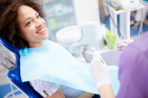 Smiling woman in dental chair looking up at dental assistant in Ferndale dentist office